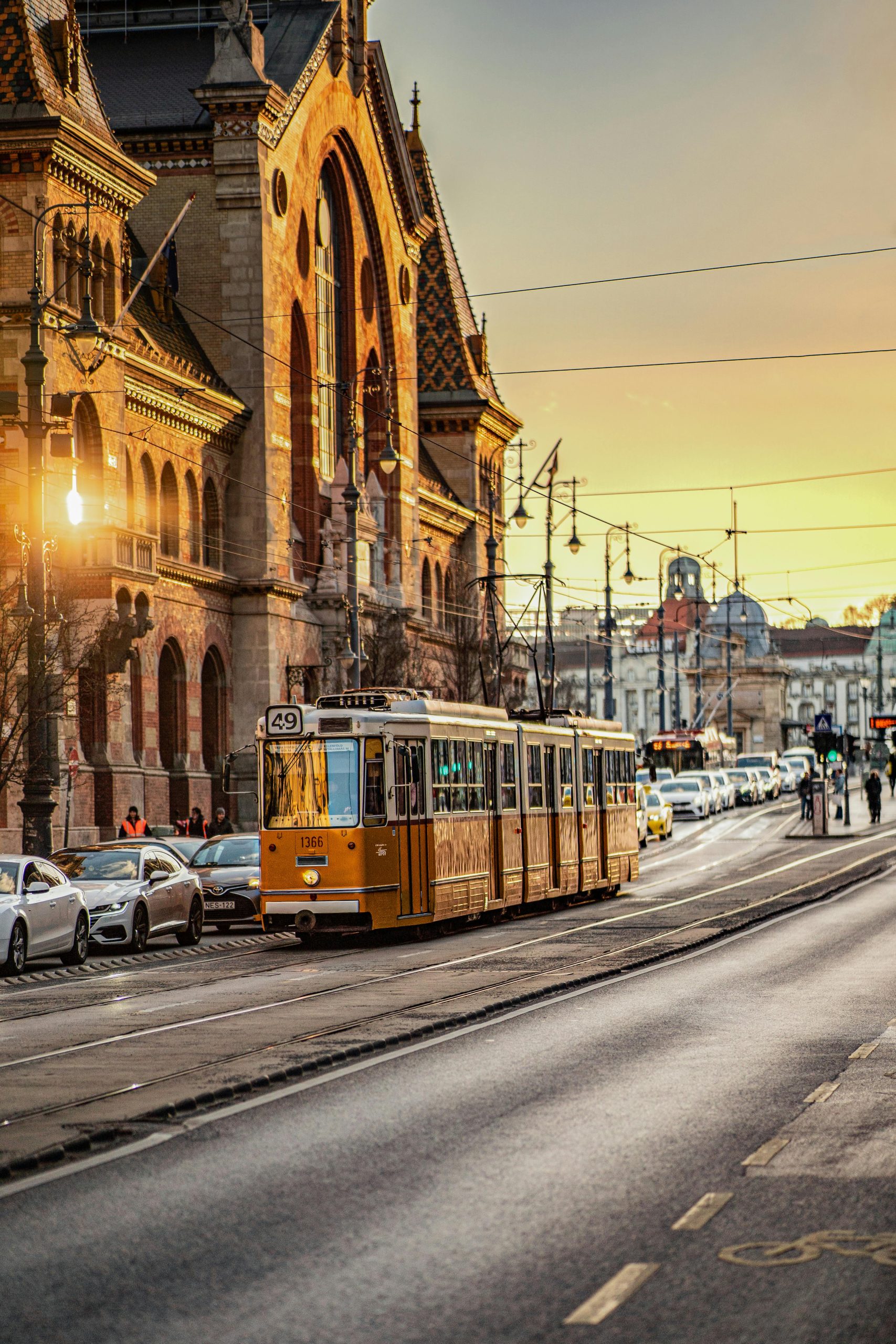 Tram 49 passing the Great Market Hall on Fővám tér at sunset — Budapest Market Tour